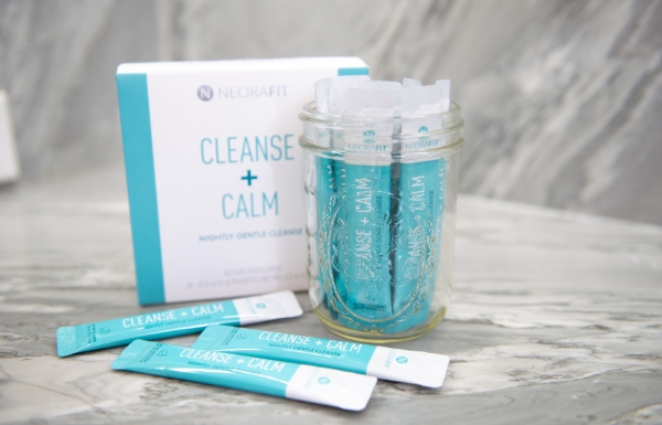 Lifestyle shot of a cup filled with NeoraFit Cleanse + Calm Nightly Gentle Cleanse Powder on a granite counter.